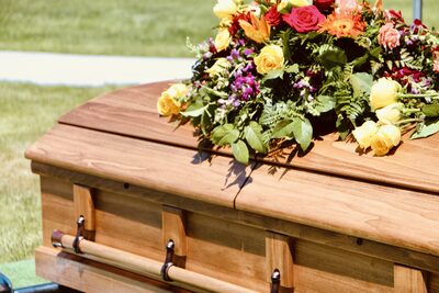 A floral arrangement resting on a wooden casket